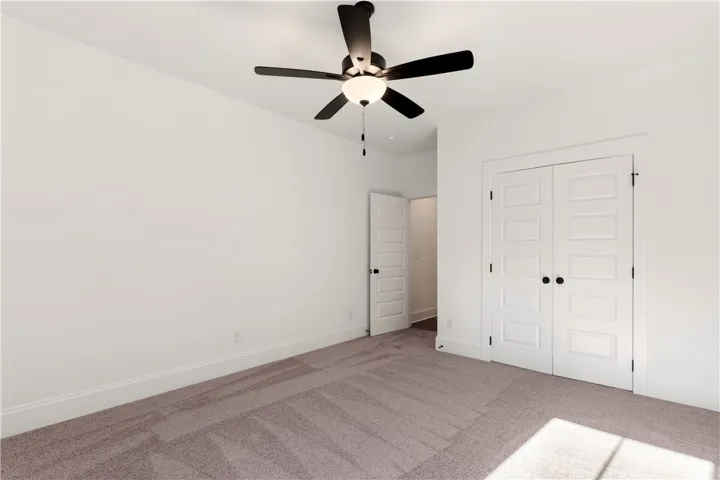Well-appointed bedroom with a ceiling fan and ample closet space awaits customization.