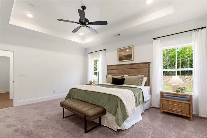 A well-lit bedroom with a tranquil outdoor view, featuring a handsome wood-paneled headboard.