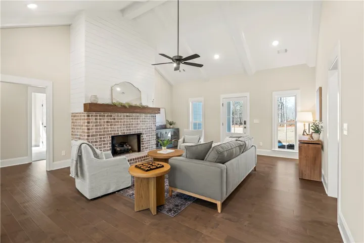 A striking fireplace with a shiplap facade anchors this spacious living area, bathed in natural light.
