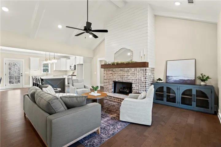 A striking brick fireplace grounds this open-concept living space with lofty vaulted ceilings.