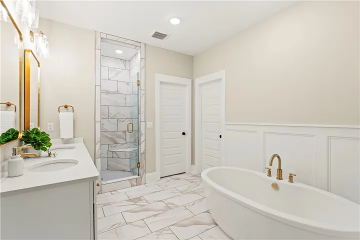 Luxurious bathing quarters with a contemporary shower and freestanding tub.