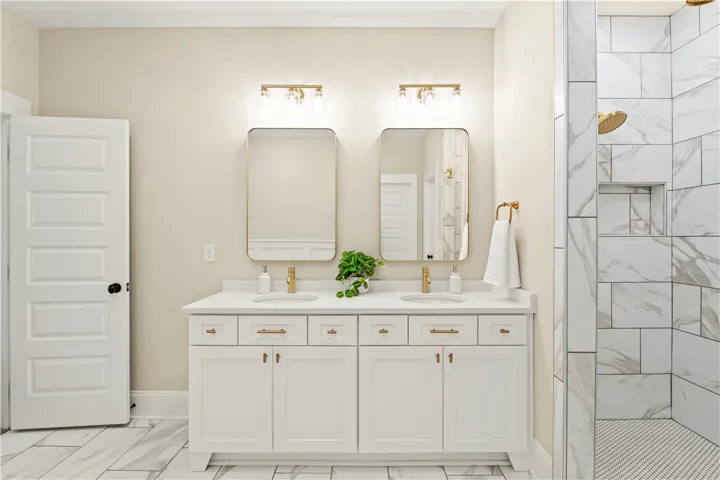 Dual vanities and a spacious walk-in shower elevate this well-appointed bathroom.