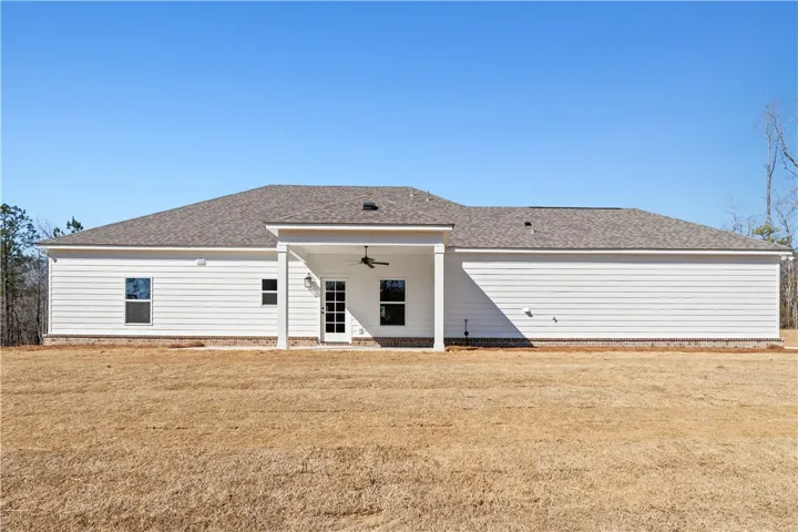 A spacious backyard awaits, featuring a covered patio ideal for outdoor enjoyment.