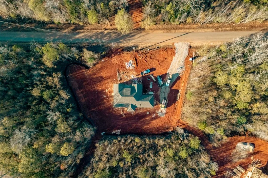 Discover a new construction home nestled in a wooded landscape, awaiting its finishing touches.
