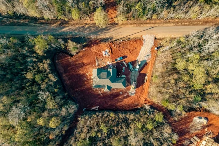 Discover a new construction home nestled in a wooded landscape, awaiting its finishing touches.