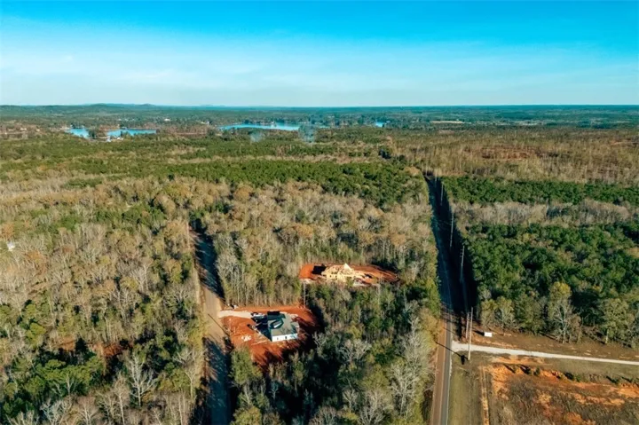 Vast, undeveloped land with mature trees and water views, primed for future construction.