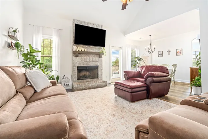 The living room showcases a vaulted ceiling and wood burning fireplace.
