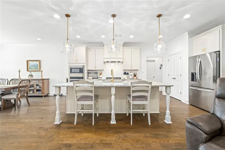 Culinary dreams come to life in this open-concept kitchen, boasting a spacious island and gleaming hardwood flooring.