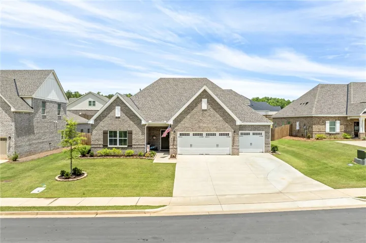 A well-maintained brick residence offers a spacious two-car garage and manicured front lawn.