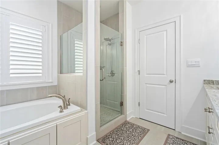Luxurious soaking tub and glass-enclosed shower create a pristine bathing experience.