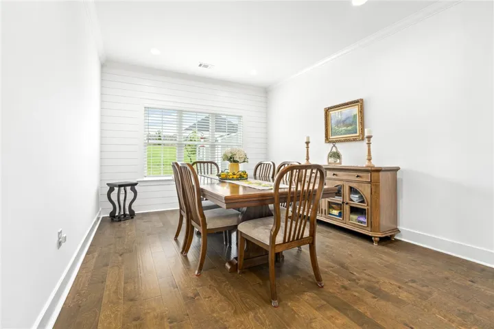 Rich hardwood flooring complements this inviting dining space, ideal for memorable meals.