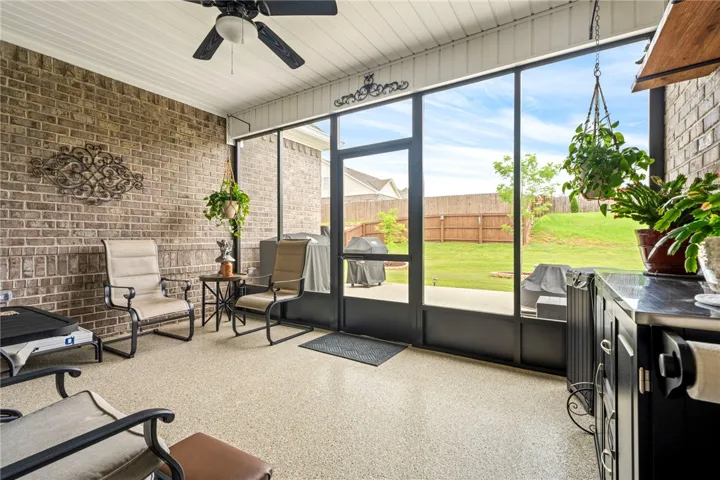 Relax and unwind in this inviting screened porch, offering serene views of the private yard.