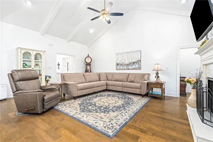 A grand living space showcasing a vaulted ceiling and rich hardwood floors.
