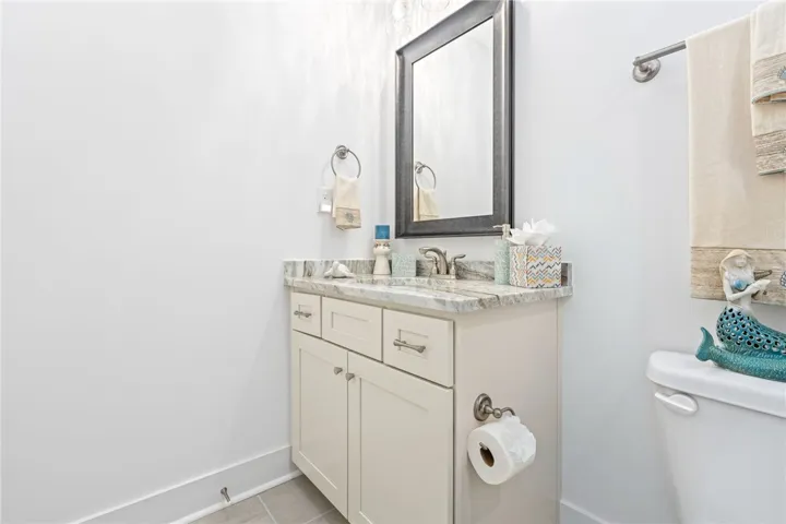 A refined bathroom featuring a contemporary vanity with a granite countertop and a sleek mirror.