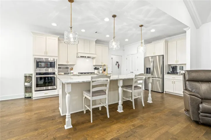 Culinary excellence awaits in this well-appointed kitchen featuring a substantial island and gleaming hardwood floors.