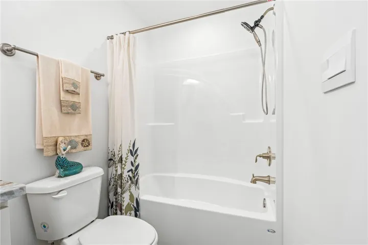 A pristine bath and shower combo offers a clean, functional space.