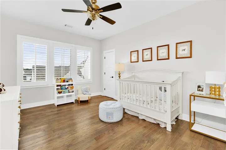Bright hardwood floors and clean white walls establish a serene and inviting nursery.