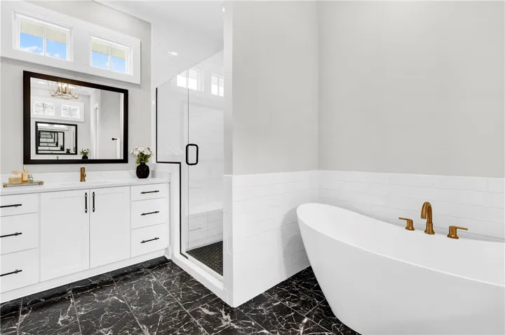 Indulge in a tranquil retreat featuring a spacious shower and a luxurious freestanding soaking tub.