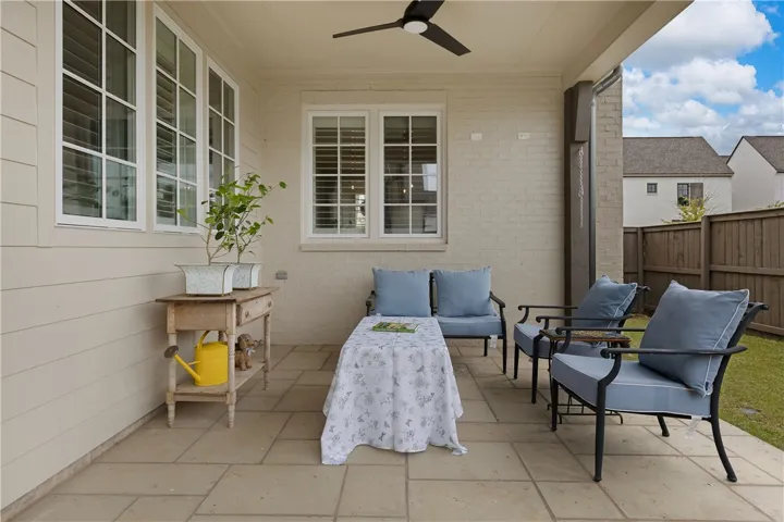 An inviting covered patio offers a comfortable retreat with a peaceful garden outlook.