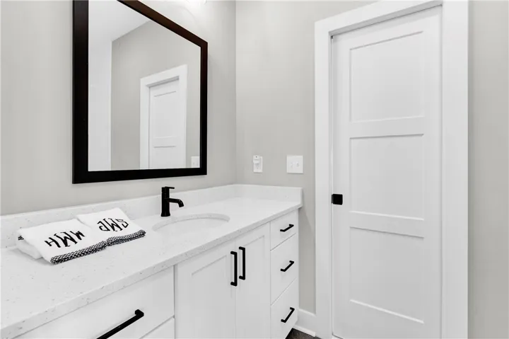 A well-appointed bathroom with clean lines, featuring a vanity with ample counter space and a modern faucet.