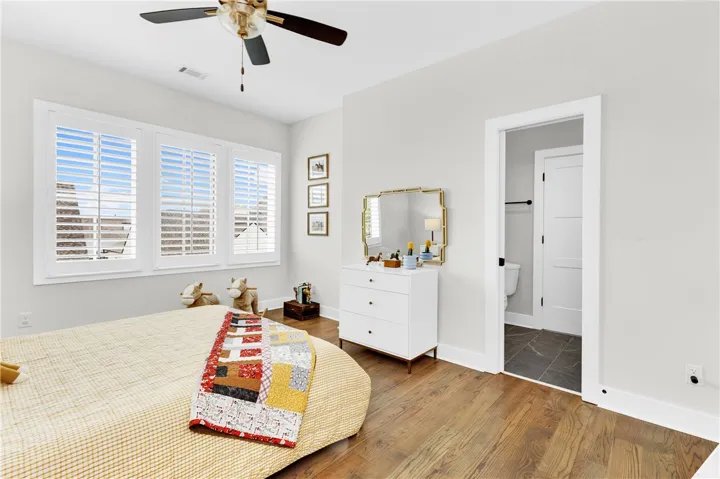 Hardwood floors and bright windows create a cheerful ambiance in this bedroom retreat.