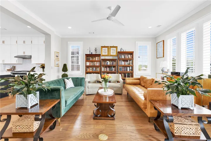 Hardwood floors and bright windows illuminate this spacious open-concept living area.
