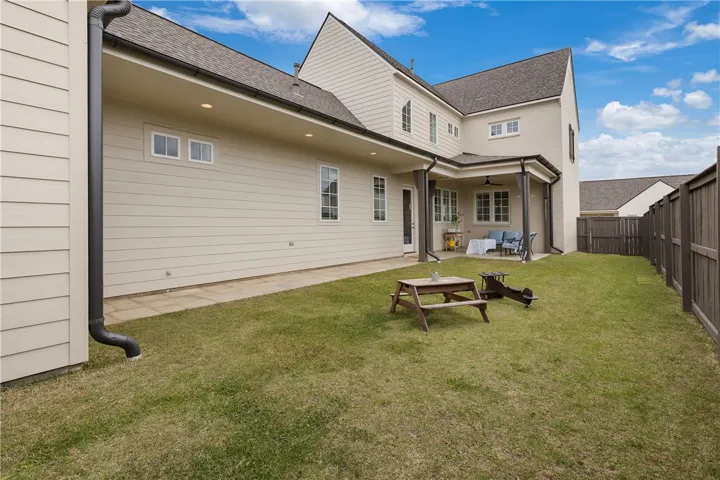 A spacious backyard provides ample green space and a covered patio for outdoor enjoyment.