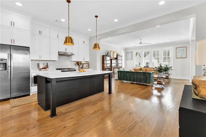 An open concept design seamlessly connects the sleek kitchen to a light-filled living area.