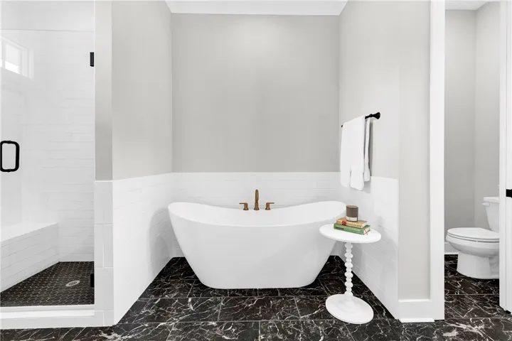 Indulge in a tranquil retreat with a freestanding tub and a spacious, naturally illuminated walk-in shower.