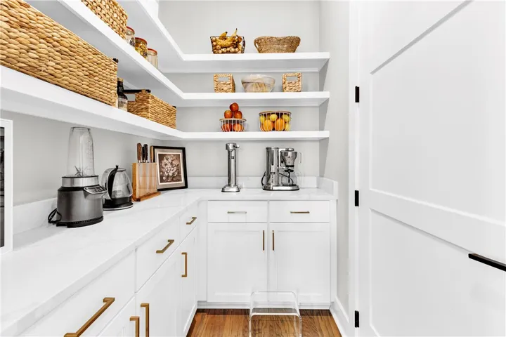 Well-appointed pantry featuring ample shelving and a convenient countertop work area.