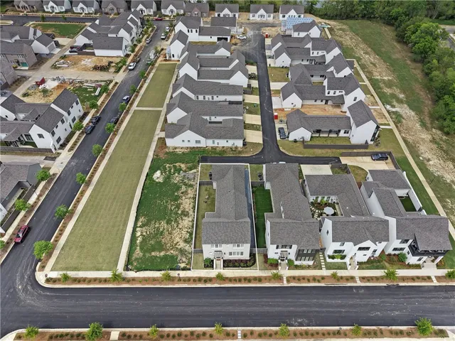 An aerial perspective showcases a vibrant residential community with newly developed homes and lush green spaces.