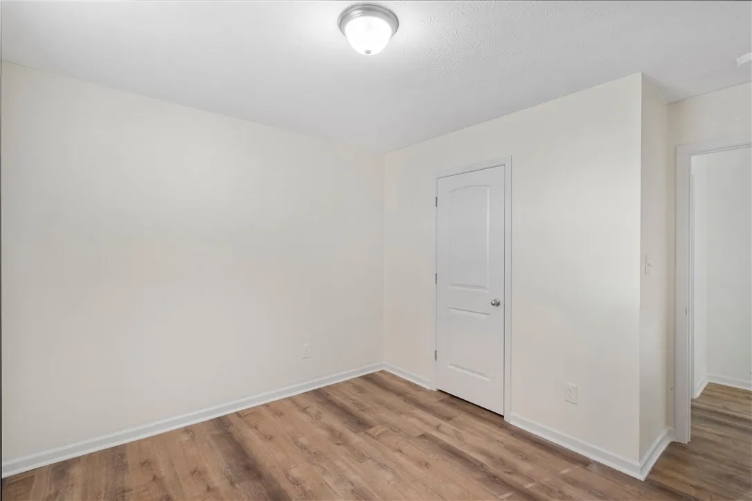 This spacious room features LVP flooring and neutral walls for a versatile living space.