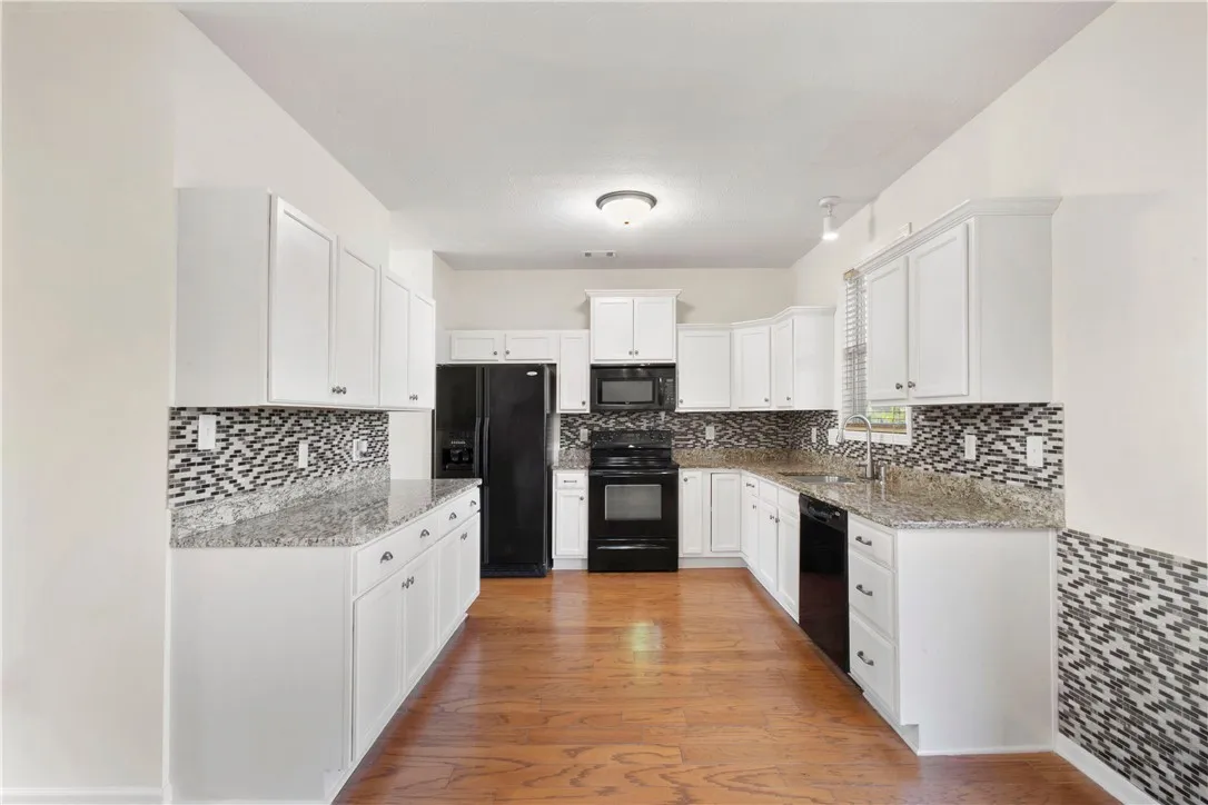 This spacious kitchen offers ample cabinetry, modern appliances, and beautiful granite countertops.