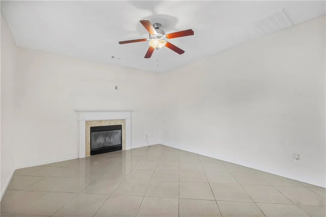 This bright room features a fireplace and sleek tiled flooring.