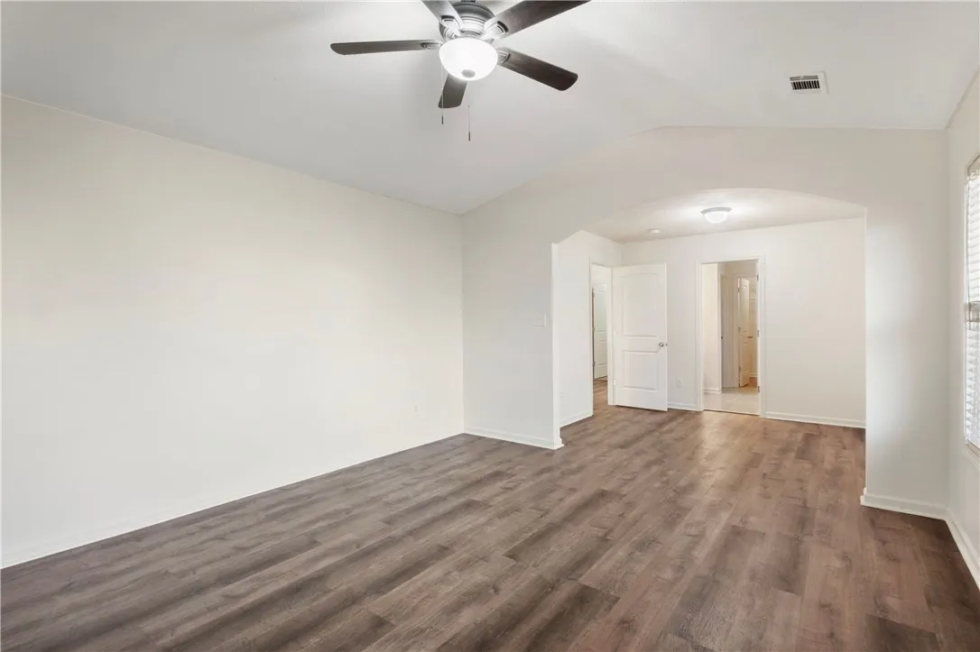 This airy room features LVP flooring and a refreshing ceiling fan.