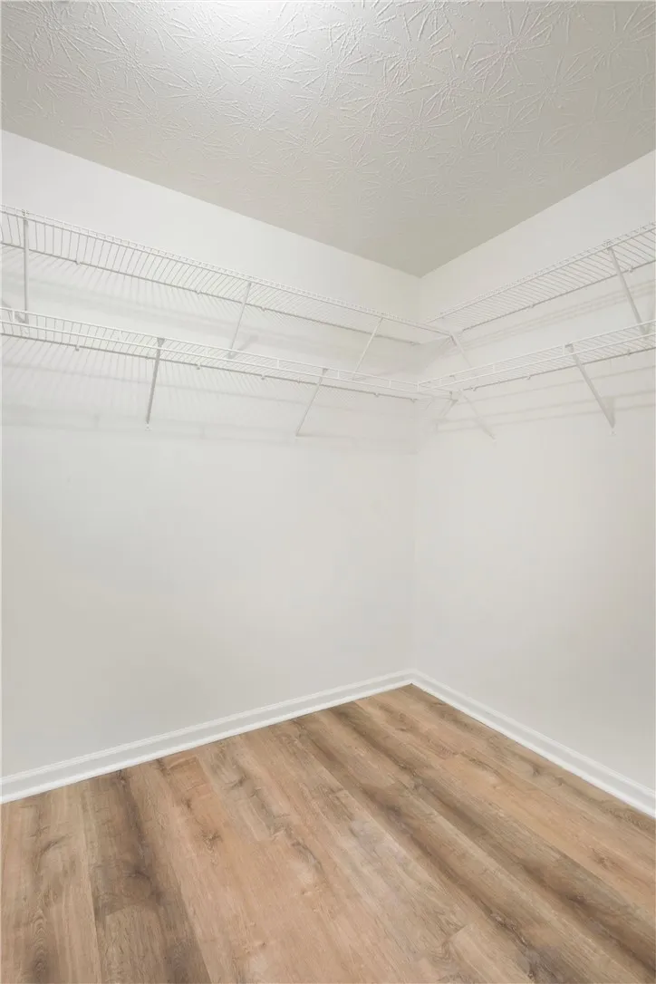 This spacious walk-in closet features ample wire shelving and LVP flooring.