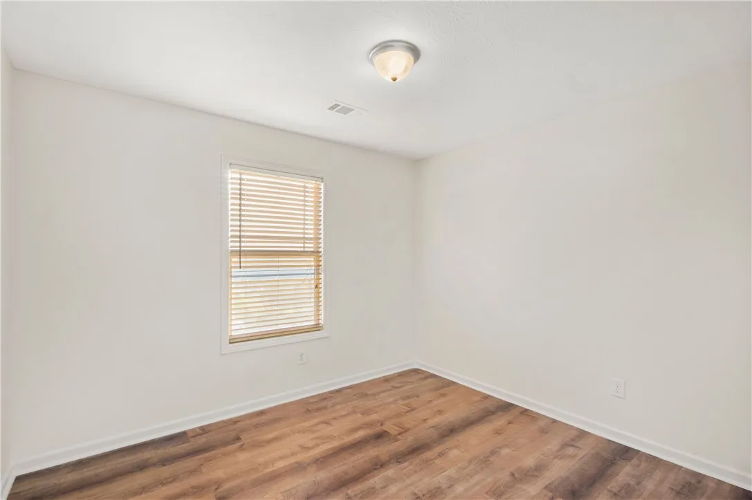 This spacious room features ample natural light and durable flooring, offering a comfortable living space.
