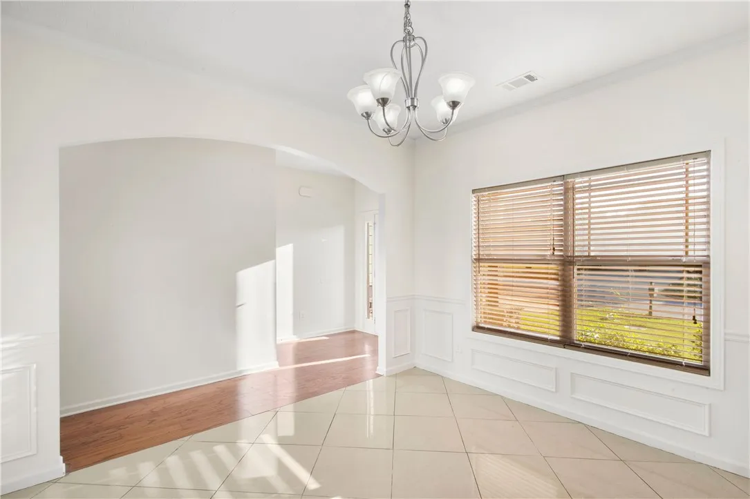 This bright, inviting dining space features elegant crown molding and a charming chandelier.