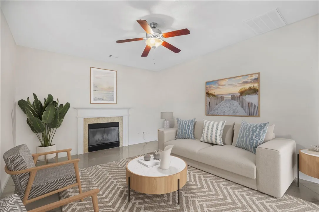 A refined living space features a cozy fireplace with a marble surround, complementing the polished flooring.