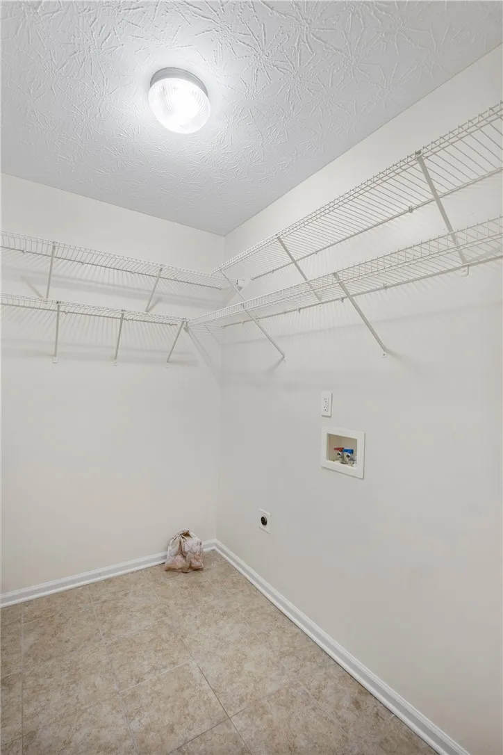 Functional laundry space with ample shelving for organized utility needs.
