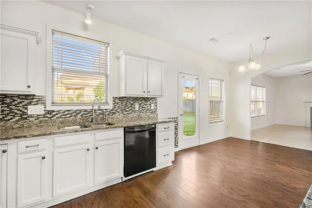 This bright kitchen features ample counter space, rich wood flooring, and direct outdoor access.