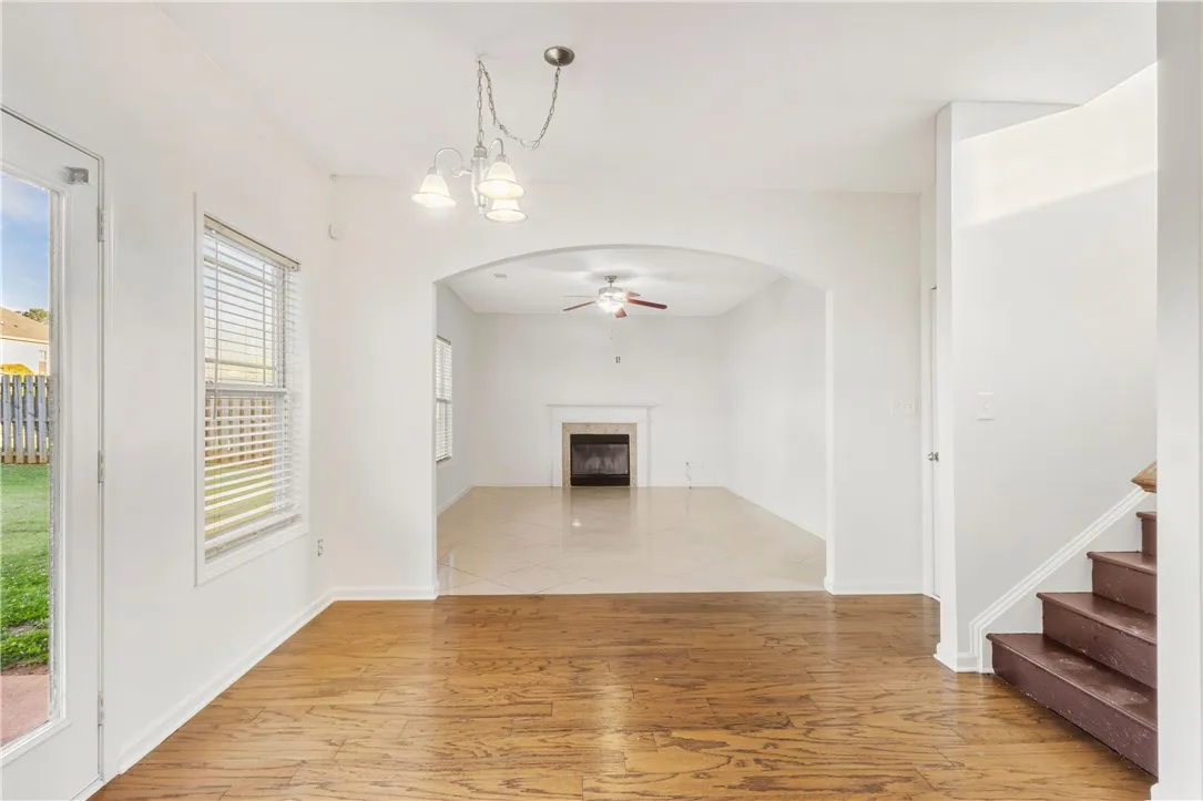 This bright living space features an inviting archway leading to a cozy fireplace and seamless outdoor access.