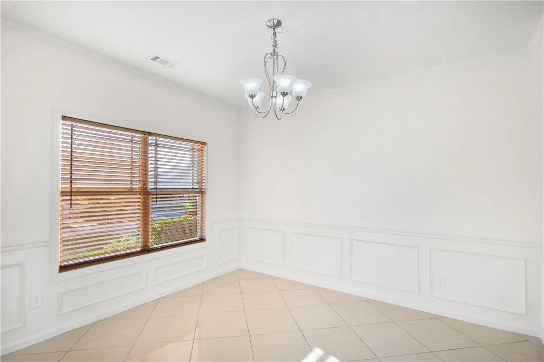 This bright room features elegant wainscoting and durable tile flooring, creating a versatile space.