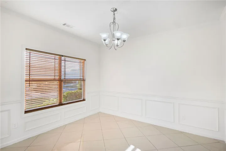 This bright room features elegant wainscoting and durable tile flooring, creating a versatile space.