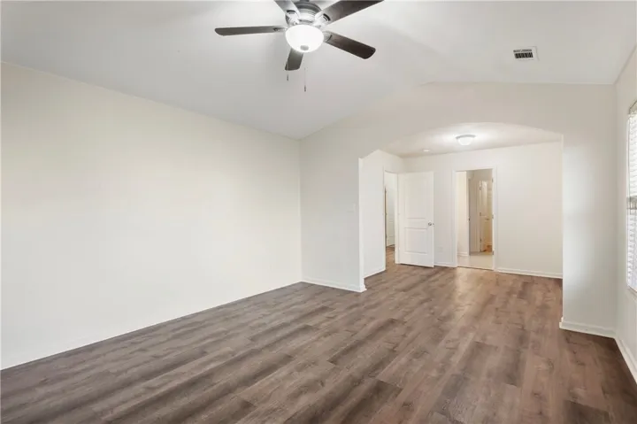 This airy room features LVP flooring and a refreshing ceiling fan.