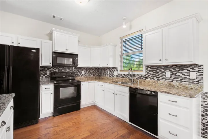 This spacious kitchen offers ample cabinet storage and stylish finishes throughout.
