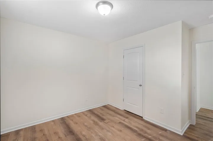 This spacious room features LVP flooring and neutral walls for a versatile living space.