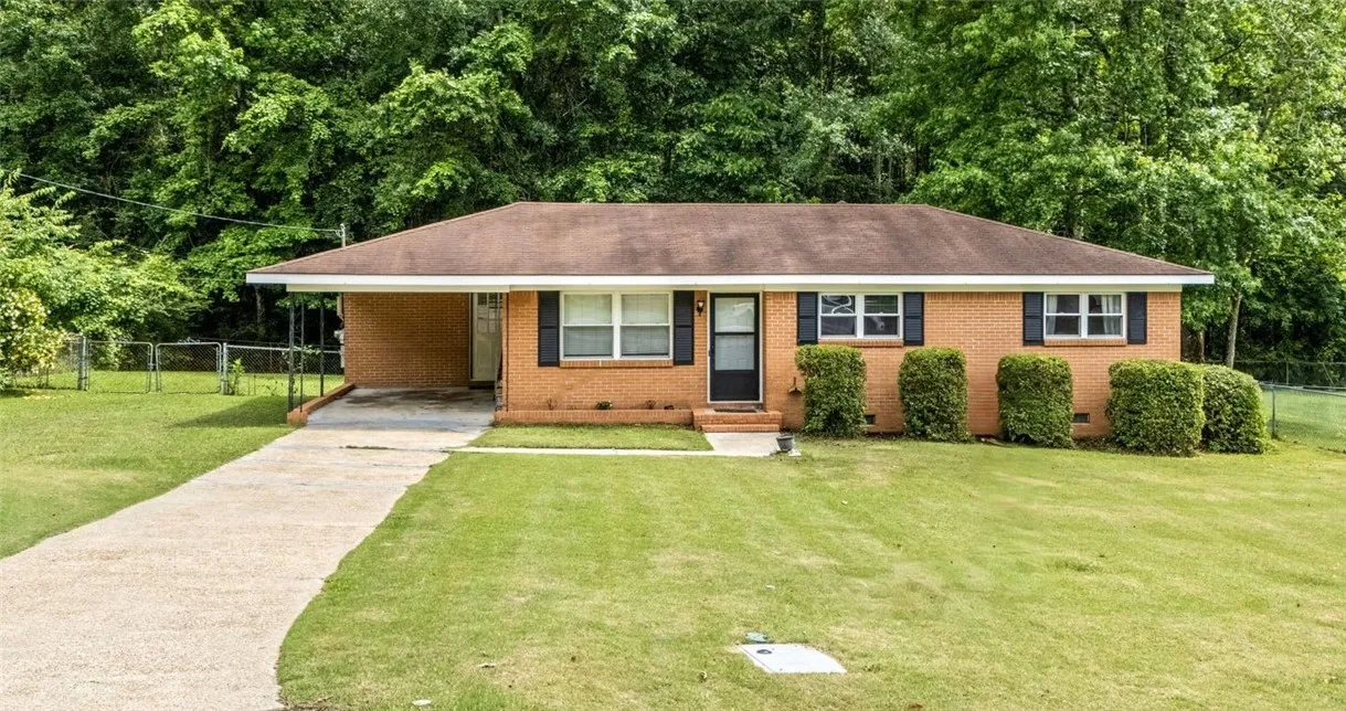 A classic brick ranch home with well-manicured hedges and a spacious front lawn awaits its next chapter.