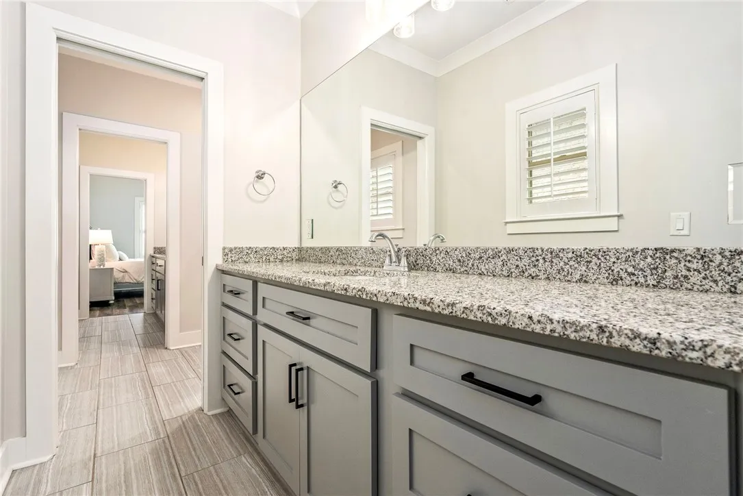 Granite counters and tiled flooring outfit this functional and practical bathroom vanity area.