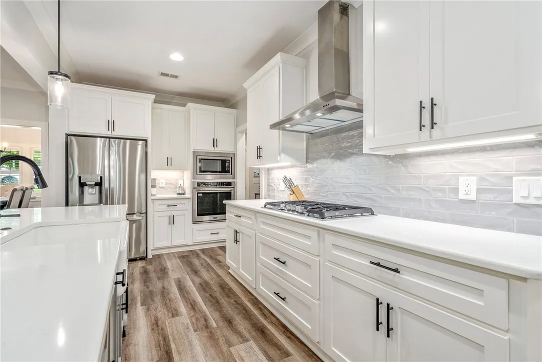 White cabinetry and stainless steel appliances complete this bright, modern culinary space.